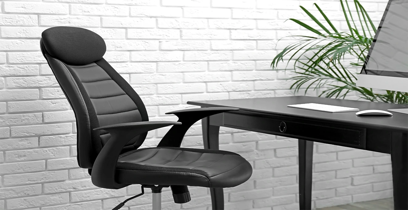 Un employé ajuste le réglage lombaire d'un fauteuil de bureau ergonomique dans une salle de réunion.